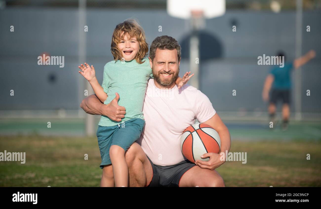 Glücklicher Vatertag. Familienportrait. Papa und Junge halten Sportball. Kind spielen Basketball. Stockfoto