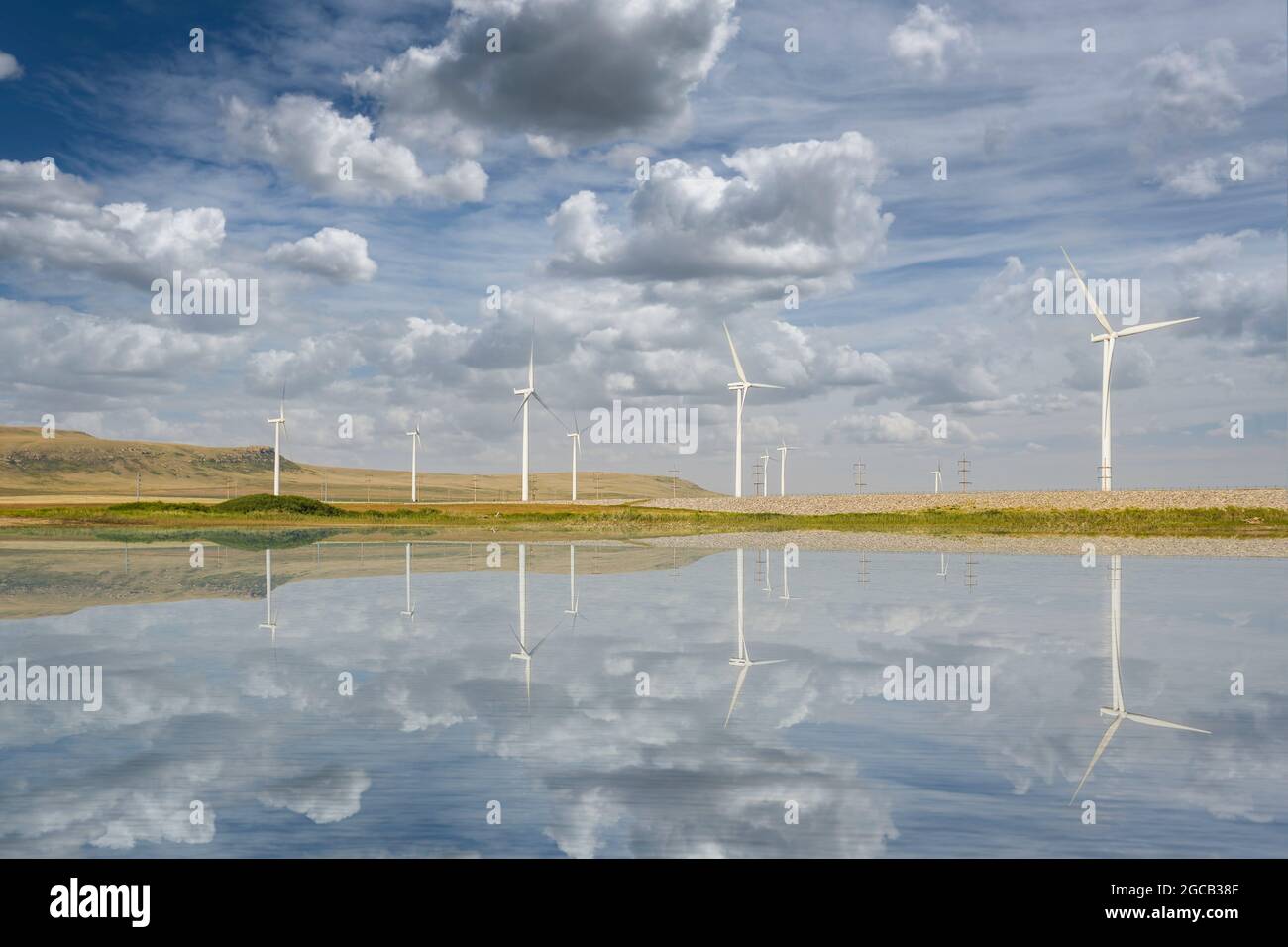 Spiegelung der Windmühlen auf dem Old man Dam See an einem sonnigen Sommertag in der Nähe von Pincher Creek, Alberta, Kanada. Stockfoto