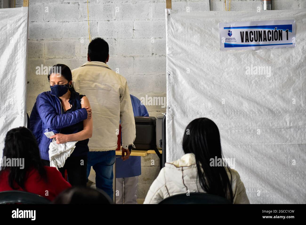 Eine Frau hält ihre Hand gegen ihren Arm, nachdem sie eine Dosis des Impfstoffs Moderna COVID-19 erhalten hat, als Menschen im Alter von 25 bis 30 Jahren am 2. August 2021 in Ipiales - Nariño, Kolumbien, ihre Impfphase mit dem neuartigen Impfstoff Moderna COVID-19 gegen die Coronavirus-Krankheit beginnen. Stockfoto