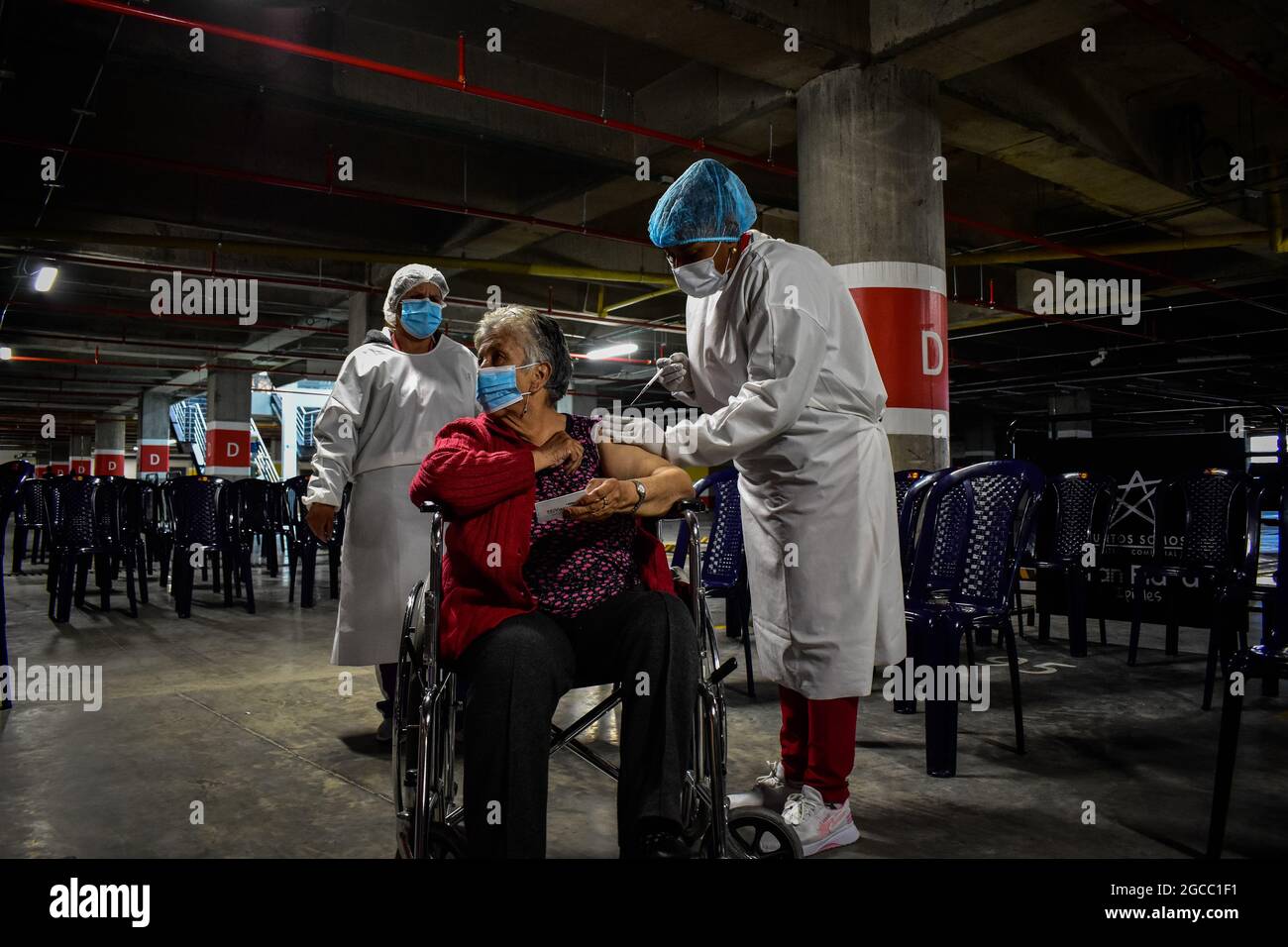 Eine Frau im Rollstuhl erhält eine Dosis des Moderna COVID-19, da Menschen im Alter von 25 bis 30 Jahren am 2. August 2021 in Ipiales - Nariño, Kolumbien, ihre Impfphase mit dem neuartigen Impfstoff COVID-19 von Moderna gegen die Coronavirus-Krankheit beginnen. Stockfoto