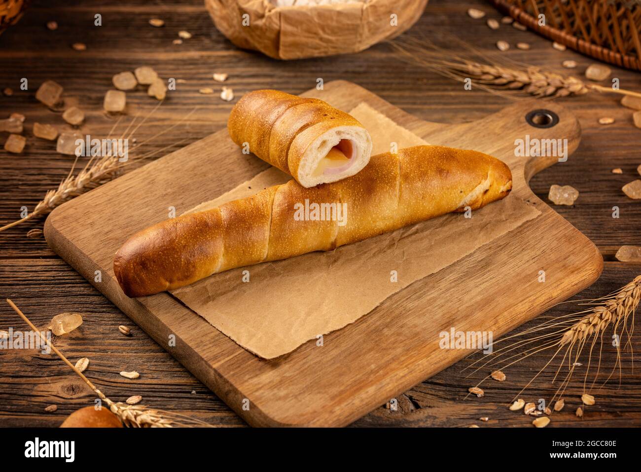 Hausgemachtes Brötchen mit Schinken und Käse auf Holzboden Stockfoto