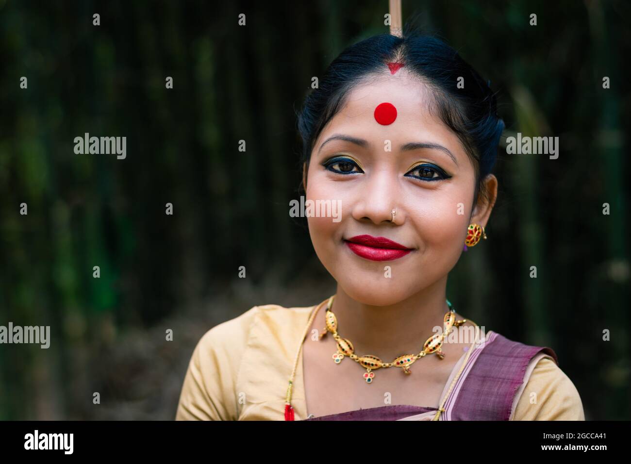 Mädchen lächelndes Gesicht isoliert in traditionellen tragen auf dem Festival mit verschwommenem Hintergrundbild gekleidet wird anlässlich der Bihu in assam indien aufgenommen. Stockfoto