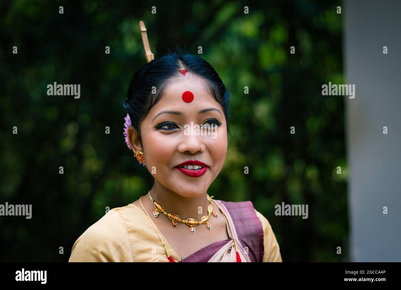 Mädchen lächelndes Gesicht isoliert in traditionellen tragen auf dem Festival mit verschwommenem Hintergrundbild gekleidet wird anlässlich der Bihu in assam indien aufgenommen. Stockfoto