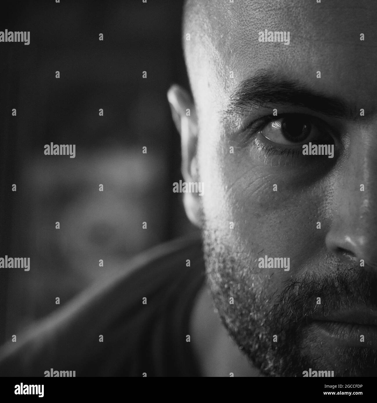 Der Blick eines weißen Mannes. Porträt, Nahaufnahme. Ein Mann mit einem Stoppeln im Gesicht. Schwarzweiß-Bild. Stockfoto