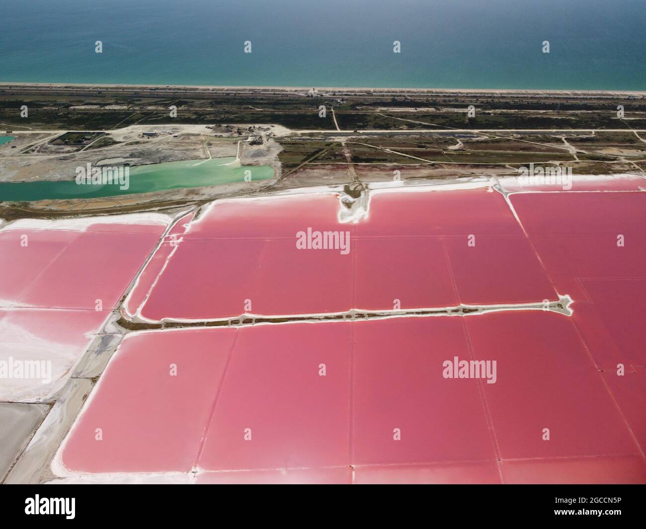 Fliegen über die rosa gefärbten Lagunen von Salzfeldern. Malerische Drohne Blick auf die bunten Salzseen an einem sonnigen Sommertag. Dunaliella Stockfoto