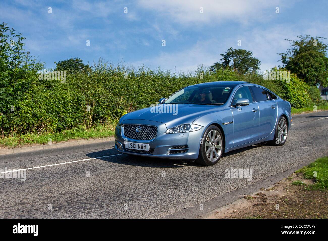 2013 grauer Jaguar V6 Portfolio 8-Gang-Automatik 2995 ccm Petyrolo 2dr-Limousine auf dem Weg zur Capesthorne Hall Classic Car Show im Juli, Ceshire, Großbritannien Stockfoto