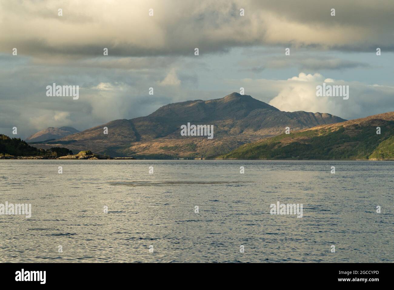 Die Berglandschaft der schottischen Highlands über ruhige See mit dramatischem bewölktem Himmel Stockfoto