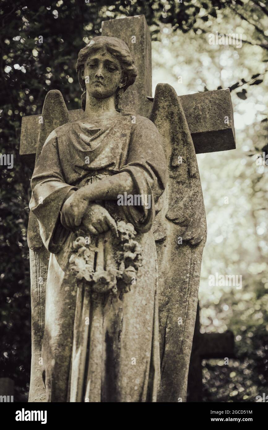 Viktorianische Steinengelstatue mit Kreuz auf dem historischen Friedhof Stockfoto