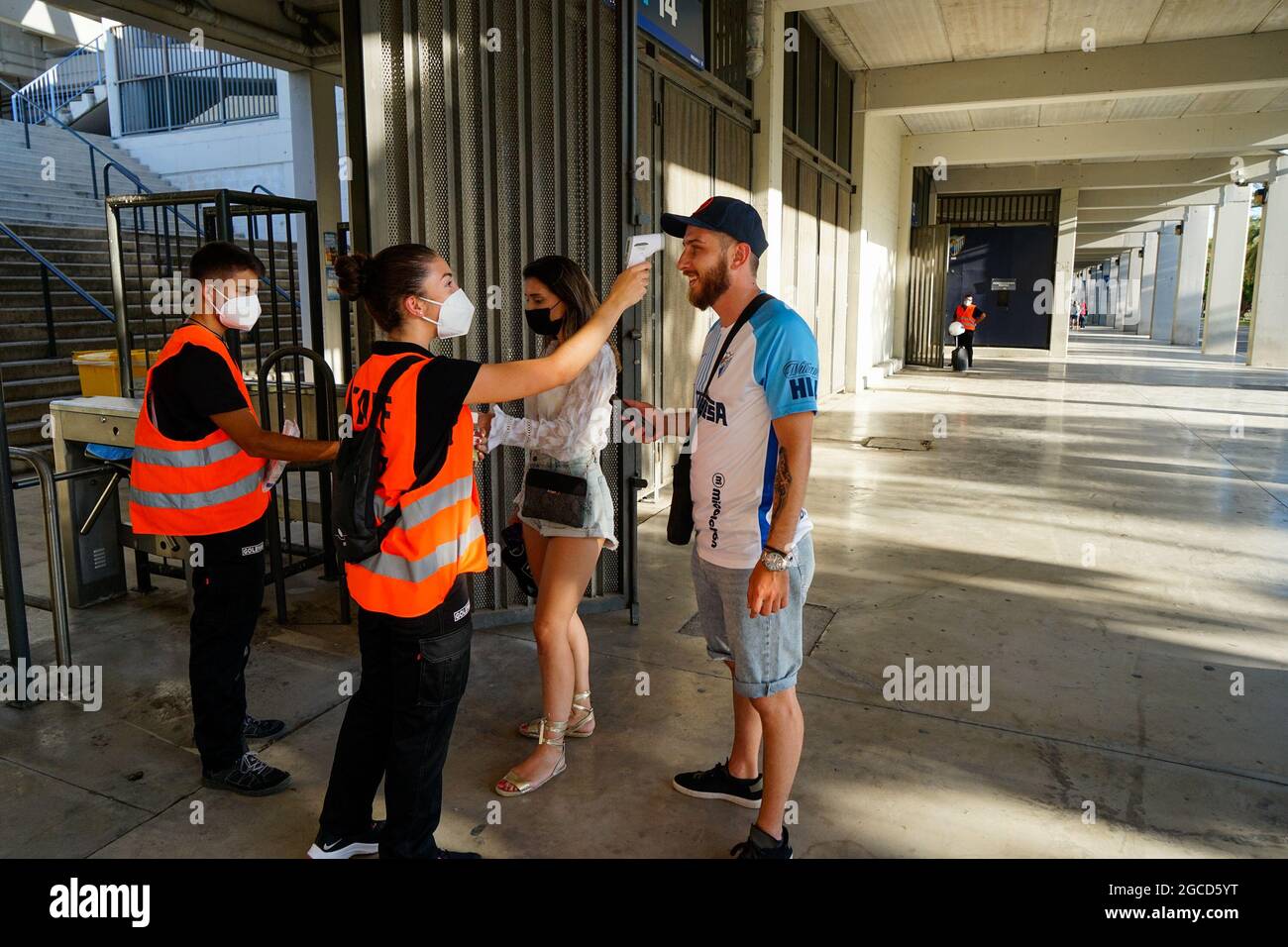 Malaga, Spanien. August 2021. Ein Sicherheitsbeamter überprüft die Temperatur eines Zuschauers vor dem Freundschaftsspiel von Malaga CF gegen CD Teneriffa im Stadion La Rosaleda, dem ersten Spiel mit 5000 Teilnehmern seit Beginn der Pandemie von Covid 19.(Endergebnis: Malaga CF 0-1 CD Teneriffa) (Foto von Francis Gonzalez/SOPA Images/Sipa USA) Quelle: SIPA USA/Alamy Live News Stockfoto