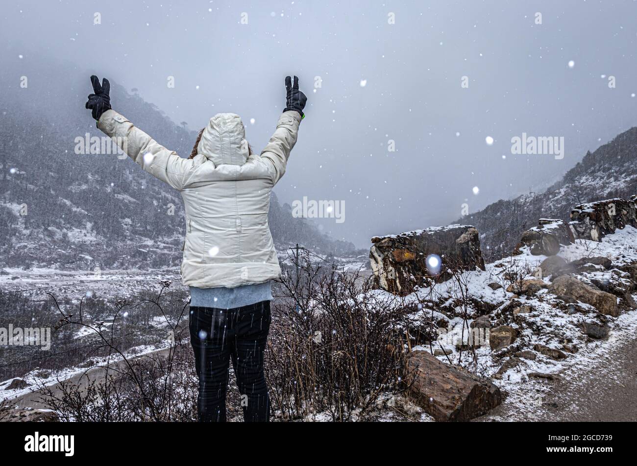 Das junge Mädchen genießt den Schneefall in den himalaya-Bergen am Morgen das Bild wird am madhuri-See tawang arunachal pradesh aufgenommen. Stockfoto