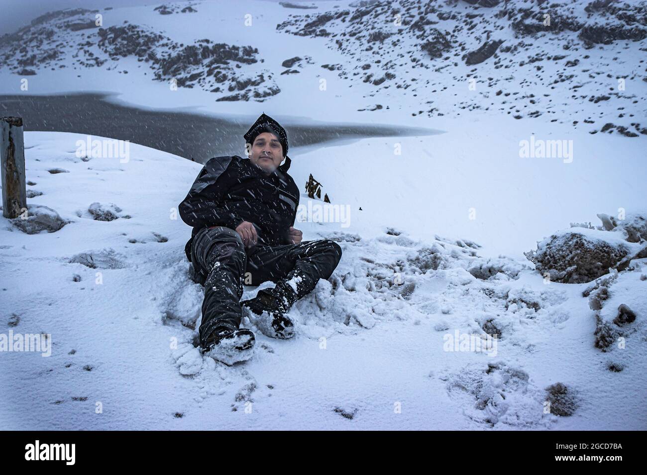 Der junge Mann, der am Morgen den Schneefall in den himalaya-Bergen genießt, nimmt das Bild am madhuri-See tawang arunachal pradesh auf. Stockfoto