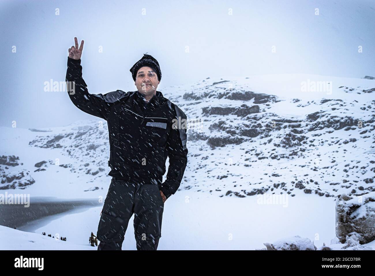 Der junge Mann, der am Morgen den Schneefall in den himalaya-Bergen genießt, nimmt das Bild am madhuri-See tawang arunachal pradesh auf. Stockfoto