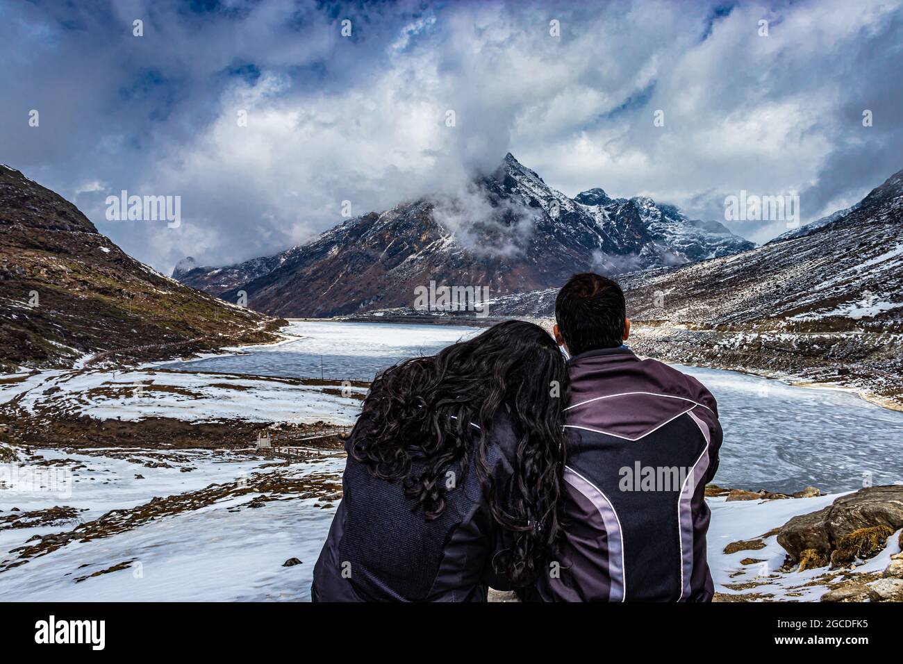 Isoliertes junges Paar, das auf der Bergspitze sitzt und am Tag einen dramatischen Himmel zeigt, wurde am sela-Pass tawang arunachal pradesh india aufgenommen. Stockfoto