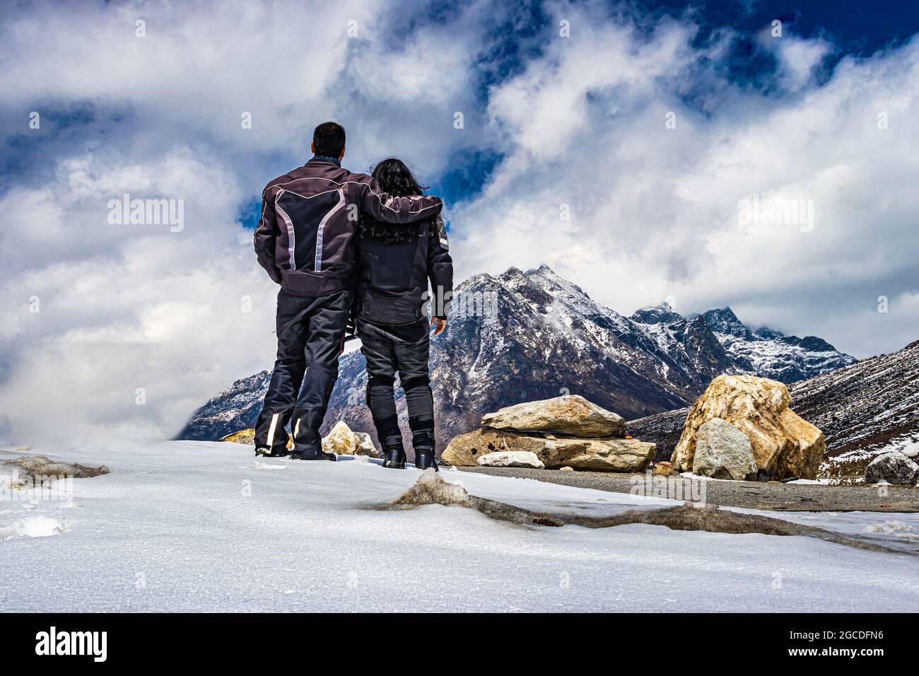 Isoliertes junges Paar, das auf der Bergspitze und am Tag am dramatischen Himmel steht, wird am sela-Pass tawang arunachal pradesh india aufgenommen. Stockfoto