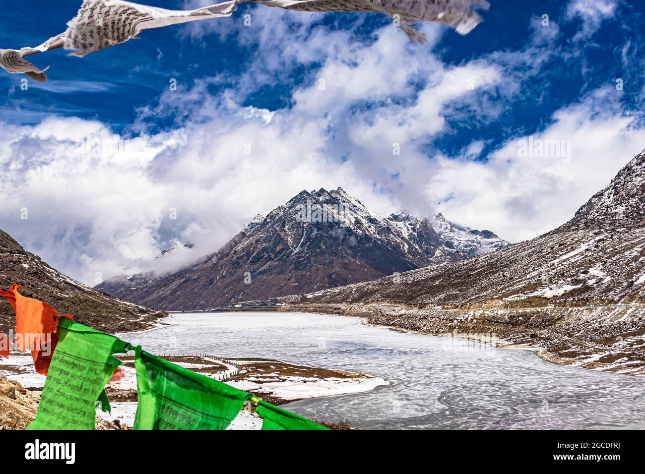 Schneedeckenberg mit dramatischem Himmel durch die verschwommenen buddhistischen Flaggen Rahmen am Tag Bild wird am sela-Pass tawang arunachal pradesh indien aufgenommen. Stockfoto