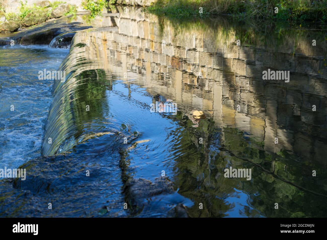 Spiegelung einer Sandsteinbrücke in fließendem Wasser abstrakter Hintergrund Stockfoto