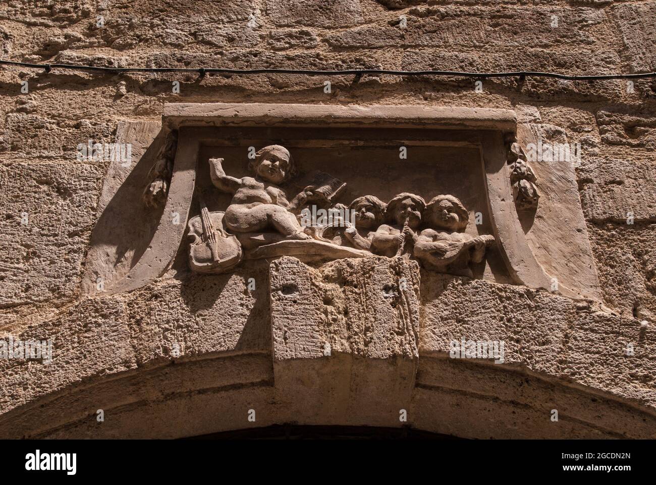 Figuren in einer Skulptur auf einem Lintel im historischen Zentrum von Pézenas, Südfrankreich. Stockfoto