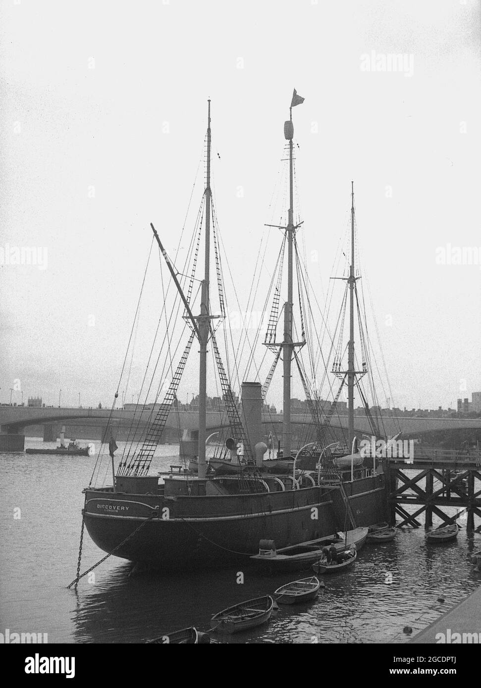 1950er Jahre, historische Ansicht des berühmten Barque-Rigged-Segelschiffs "RRS Discovery" auf der Themse, London, England, Großbritannien, das letzte hölzerne Dreimast-Schiff, das in Großbritannien gebaut wurde. Sie war ein Segelschiff mit einem zusätzlichen Dampfantrieb und wurde in Dundee, Schottland, gebaut. Ihre erste Reise, die als Discovery Expedition (1901-1904) bekannt ist, wurde speziell für die Antarktisforschung gebaut und führte die britischen Forscher Robert Falcon Scott und Ernest Shackletone in die Region. Nachdem sie von 1929 bis 1931 in der australischen Antarktis war, wurde sie als statisches Trainingsschiff und Besucherattraktion auf der Themse festgemacht. Stockfoto