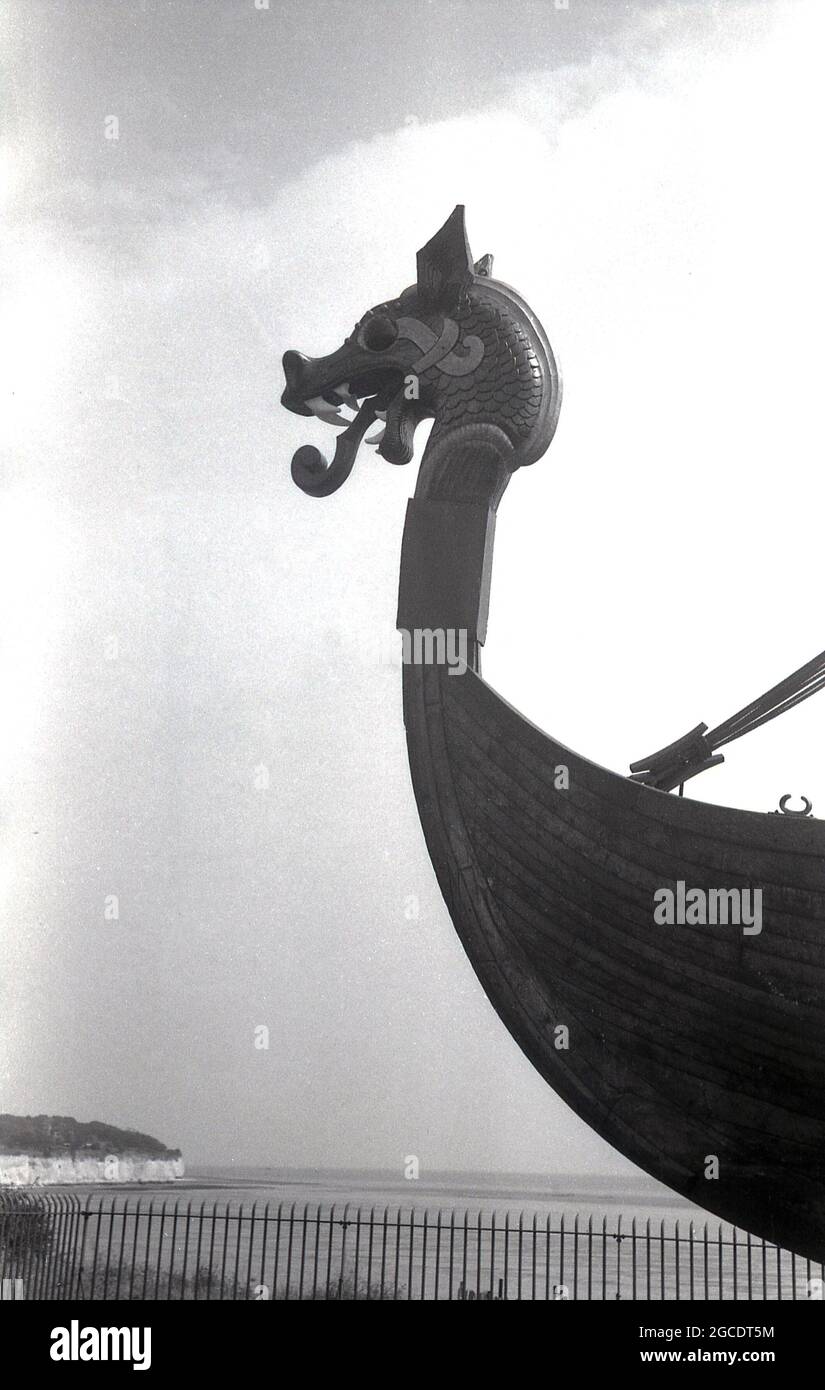 Der Kopf des Wikingerschiffs oder Longboats „Hugin“ aus den 1960er Jahren, der an der Küste auf der Klippe der Pegwell Bay, Ramsgate, Kent, England, Großbritannien, ausgestellt wird. Ein rekonstruiertes Langschiff, die Hugin, ein Geschenk der dänischen Regierung zum Gedenken an den 1500. Jahrestag von Hengist und Horsa, den Führern der angelsächsischen Invasion in der nahe gelegenen Ebbsfleet, kam 1949 in Viking Bay, Broadstairs, an. Es ist eine Nachbildung des Gokstad-Schiffes, ca. 890. Stockfoto