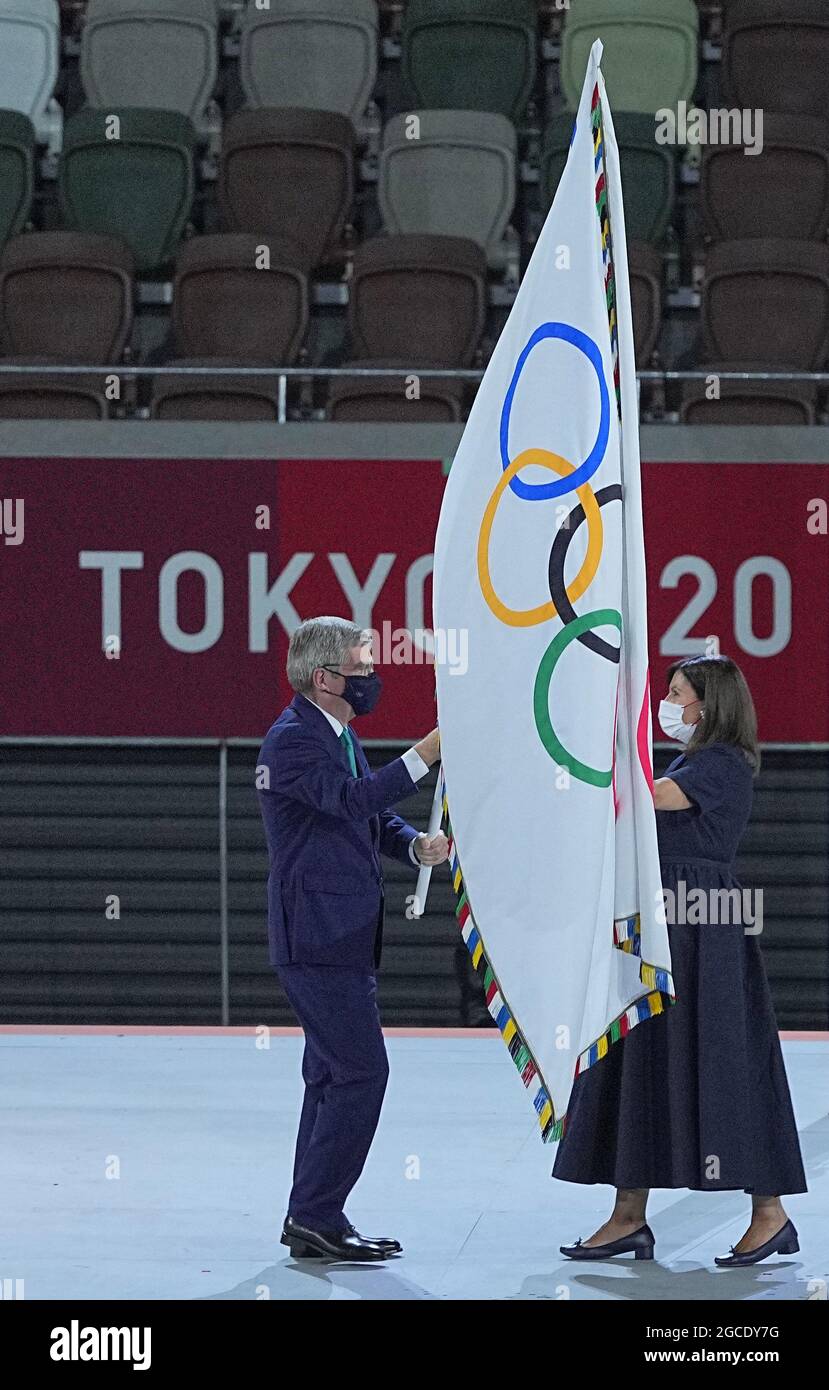 Tokio, Japan. August 2021. Olympische Spiele: Abschlussfeier im Olympiastadion. Der Präsident des Internationalen Olympischen Komitees, Thomas Bach (l.), übergibt die olympische Flagge an die Bürgermeisterin von Paris, Anne Hidalgo. Quelle: Michael Kappeler/dpa/Alamy Live News Stockfoto