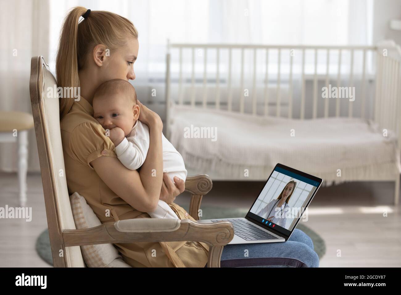 Junge Mutter mit Baby Gespräch auf Videoanruf mit Arzt Stockfoto