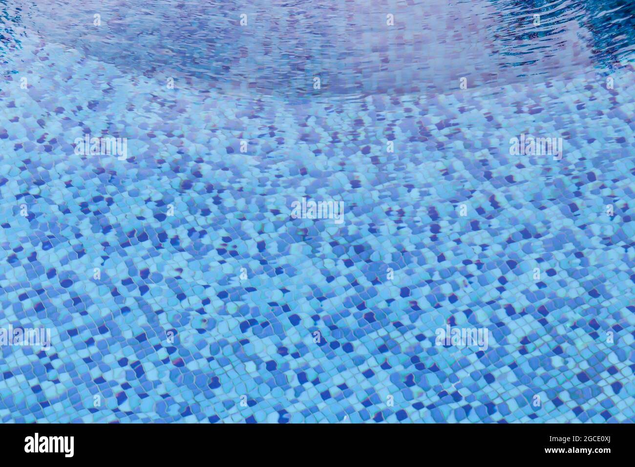 Wellenwasser im Swimmingpool mit Blick auf Unterwasser-Fliesen. Stockfoto