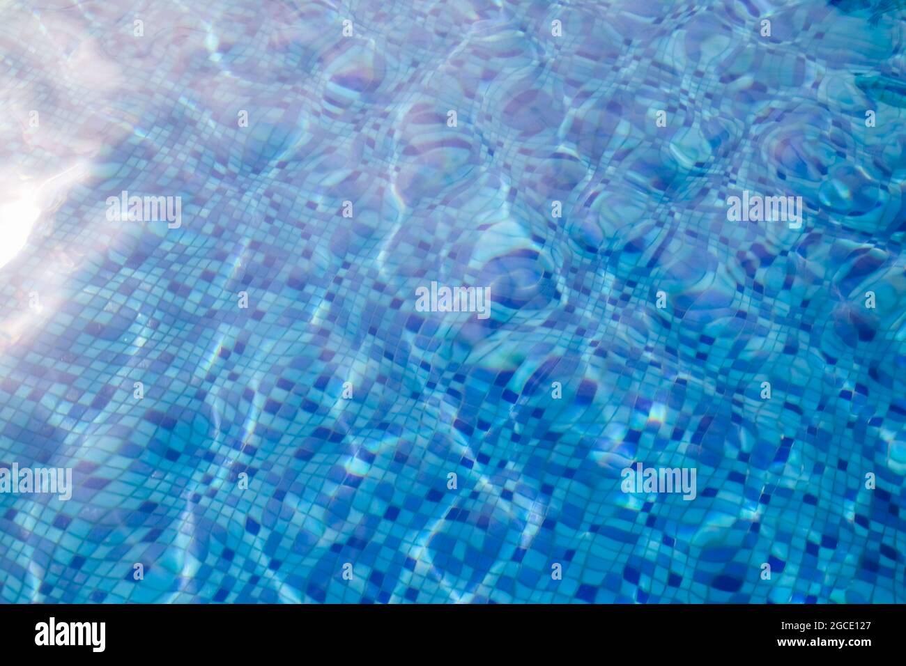 Wellenwasser im Swimmingpool mit Blick auf Unterwasser-Fliesen. Stockfoto