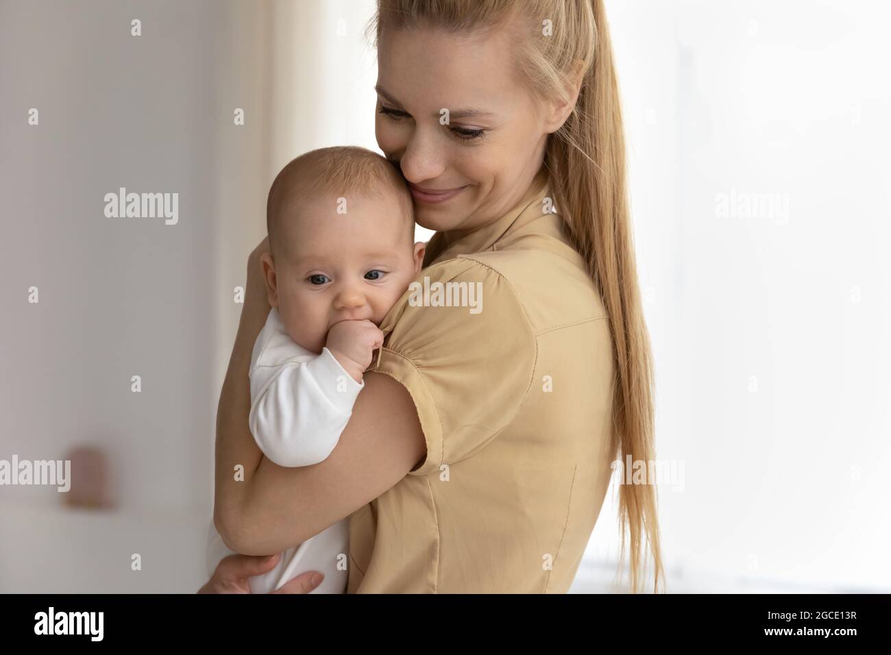Liebende junge Mutter lull umarmen neugeborenen Säugling Stockfoto