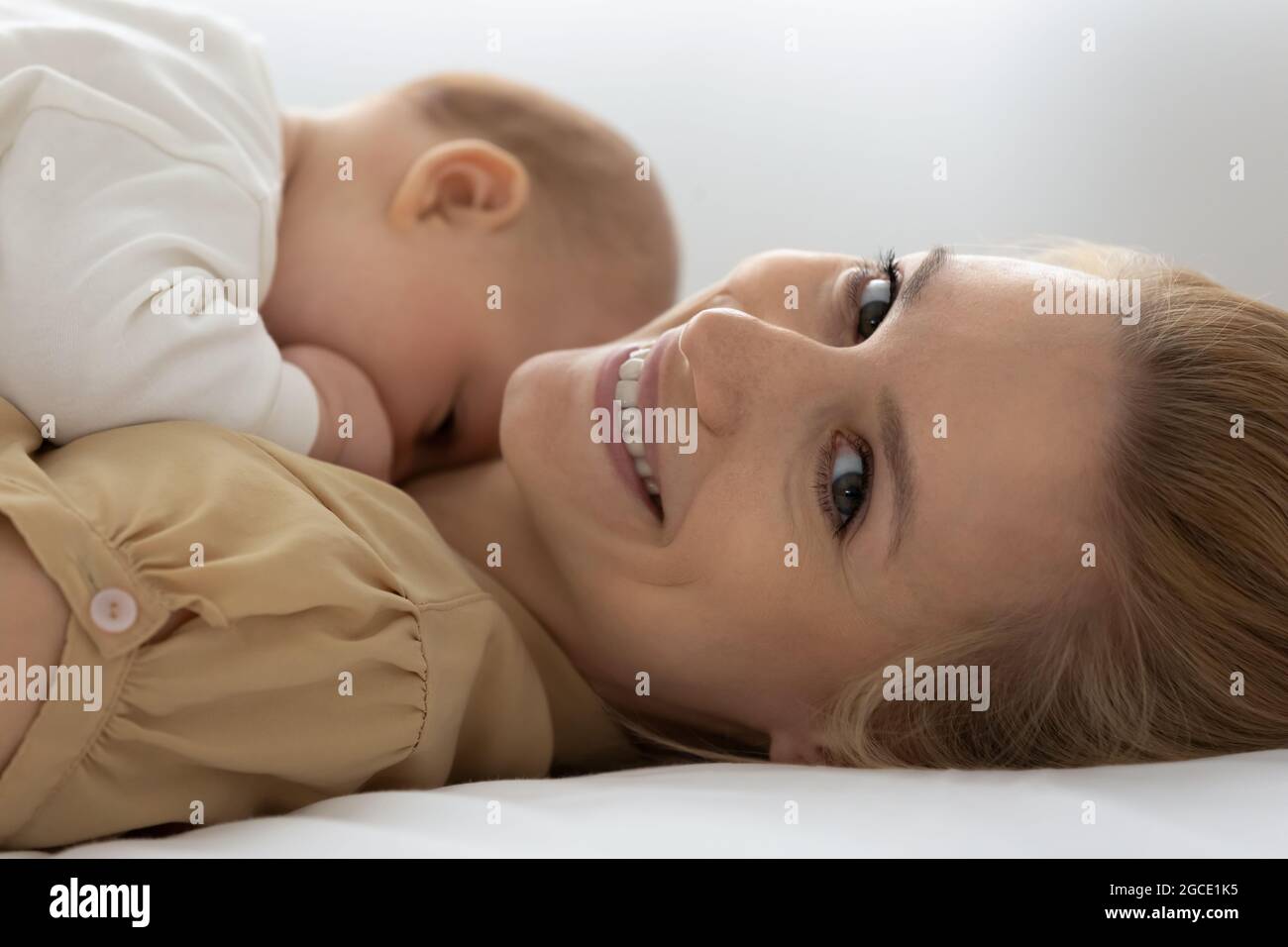 Nahaufnahme des Portraits einer lächelnden Mutter mit einem neugeborenen Baby Stockfoto