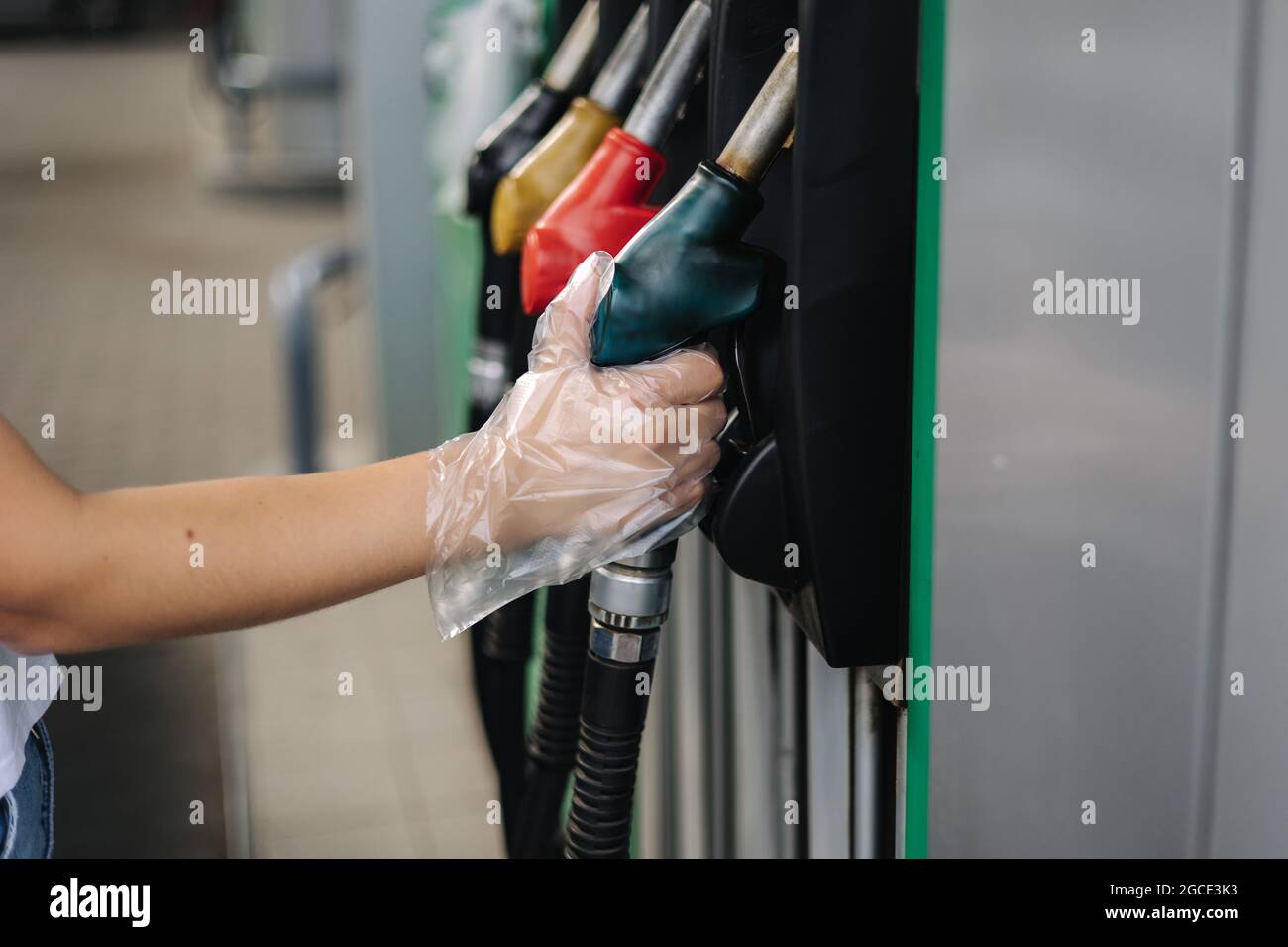 Nahaufnahme einer Frauenhand mit einer Zapfpistole an einer Tankstelle. Tankstellenkonzept. Tankstelle bei Benzin Stockfoto