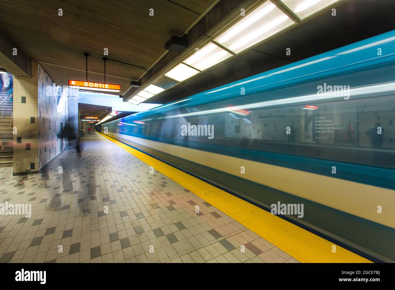 Eine U-Bahn fährt vorbei, während die Leute warten. Die Metro von Montreal (Métro de Montréal) ist eine gummimüde U-Bahn, Montreal, Quebec Stockfoto