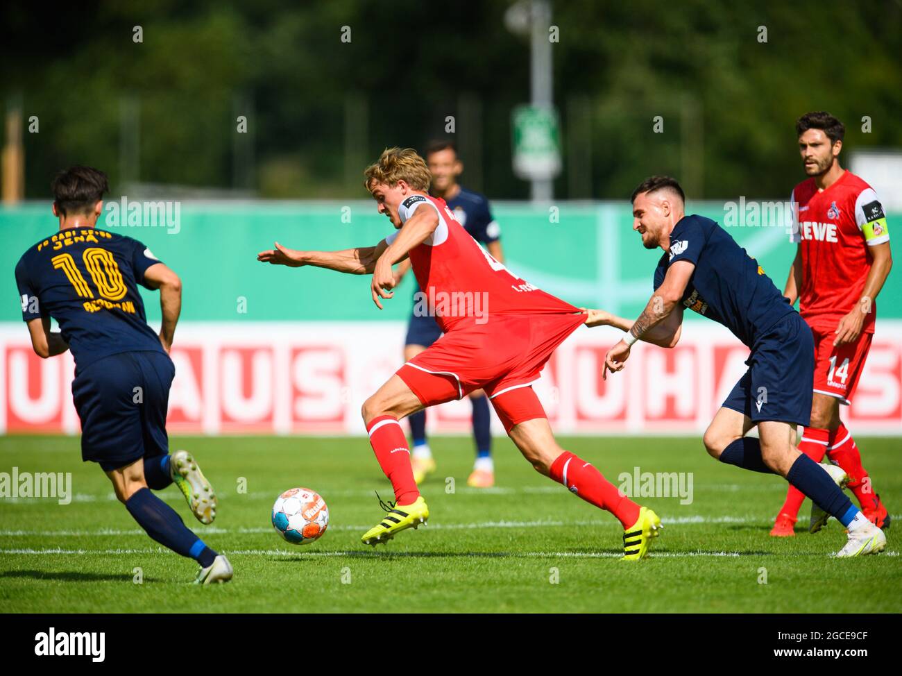 08. August 2021, Thüringen, Jena: Fußball: DFB-Pokal, FC Carl Zeiss Jena -  1. FC Köln, 1. Runde, im Ernst-Abbe-Sportfeld. Jenaer Maximilian Wolfram  (2. Von rechts) hält Kölns Timo Hübers im Trikot. Jenaens