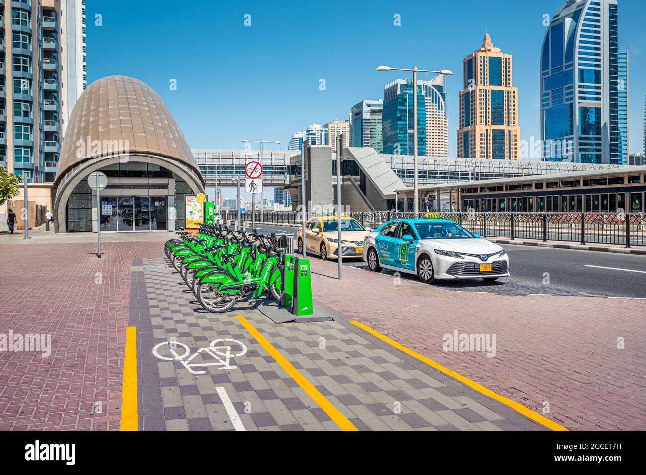 23. Februar 2021, Dubai, VAE: Fahrradverleih von Careem, Metro-Eingang und Taxistand, als Stadt Öffentliche Verkehrsmittel Stockfoto