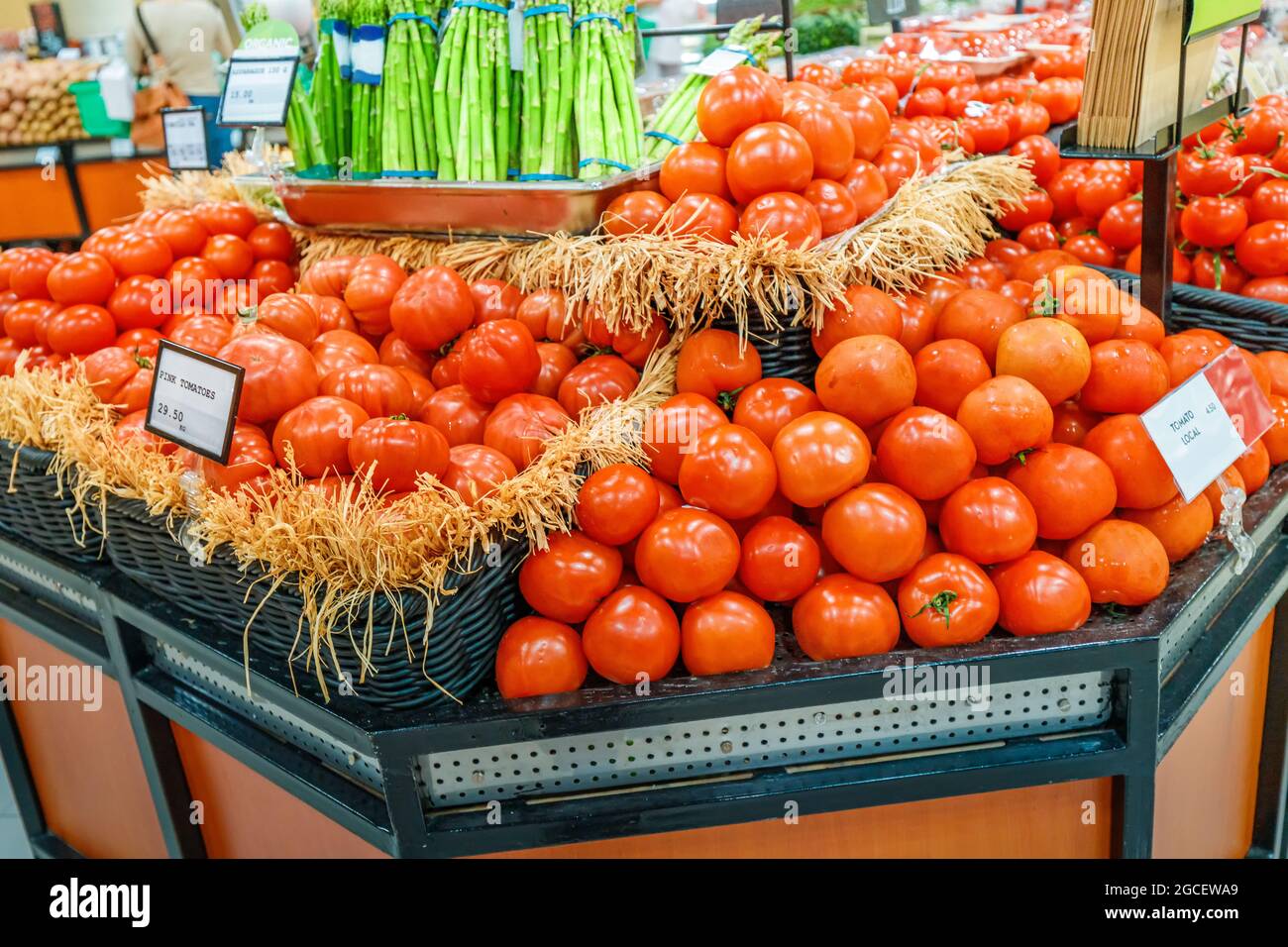 Rosafarbene Bio-Tomaten ohne GVO und Pestizide in den Supermarktregalen in der Lebensmittelabteilung Stockfoto