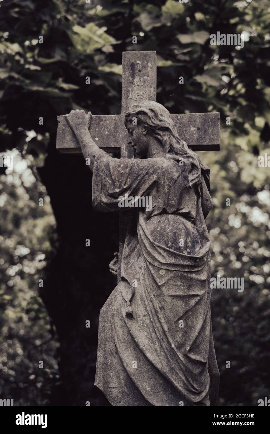 Viktorianische Steinengelstatue mit Kreuz auf dem historischen Friedhof Stockfoto