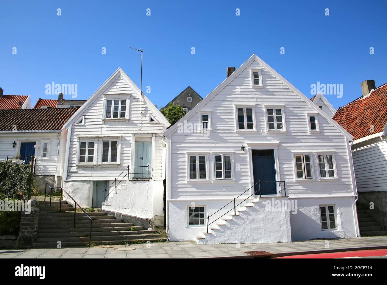 Traditionelle Holzhäuser, die alle weiß gestrichen sind mit roten Dächern. Das Hotel liegt in Gamle Stavanger, einem historischen Viertel der Stadt Stavanger, Norwegen. Stockfoto