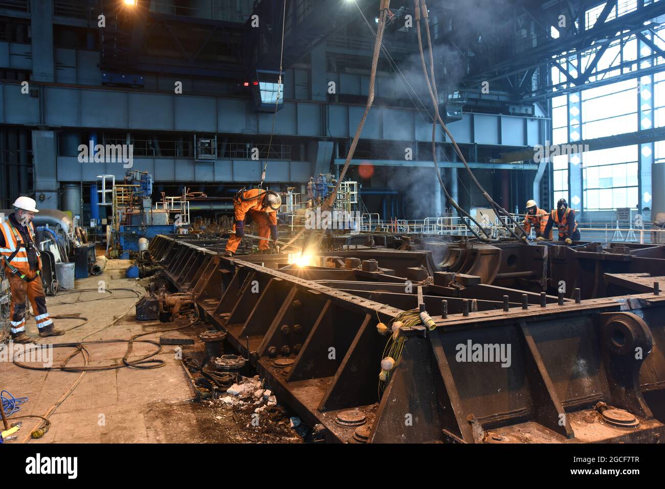 Abbrucharbeiter schneiden Eisen und Stahl mit Acetylenbrenner in der Turbinenhalle des Kraftwerks Buildwas 2019. Stillgelegte Ironbridge Großbritannien Abriss Industriegelände Stockfoto