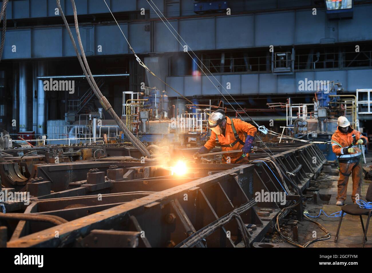 Abbrucharbeiter schneiden Eisen und Stahl mit Acetylenbrenner in der Turbinenhalle des Kraftwerks Buildwas 2019. Stillgelegte Ironbridge Großbritannien Abriss Industriegelände Stockfoto