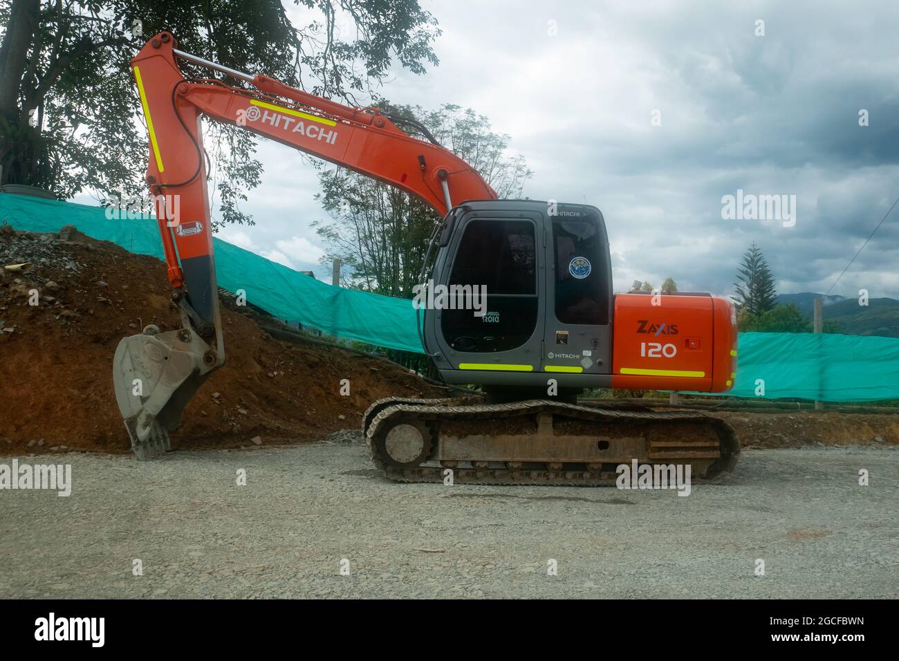 Amada, Antioquia, Kolumbien - Juli 18 2021: Orange Crane entfernt einen Erdhaufen für den Bau einer neuen Fahrbahn Stockfoto