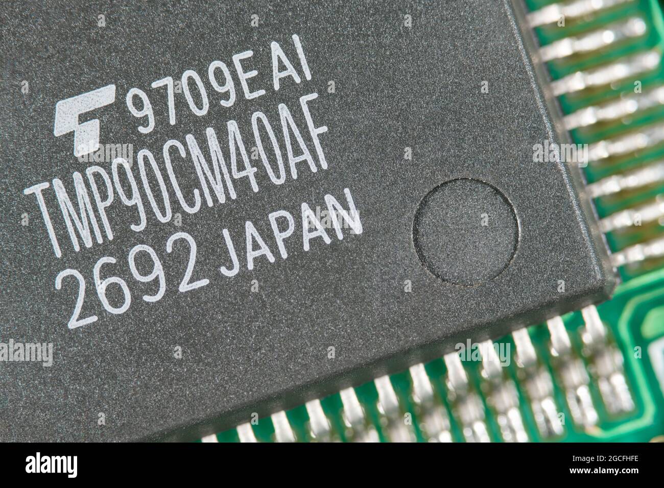 Makroaufnahme eines vermutlich von Toshiba produzierten CMOS 8-Bit-Mikrocontrollers aus Japan. Für den Mangel an Mikrochips, kleine elektronische Teile Stockfoto