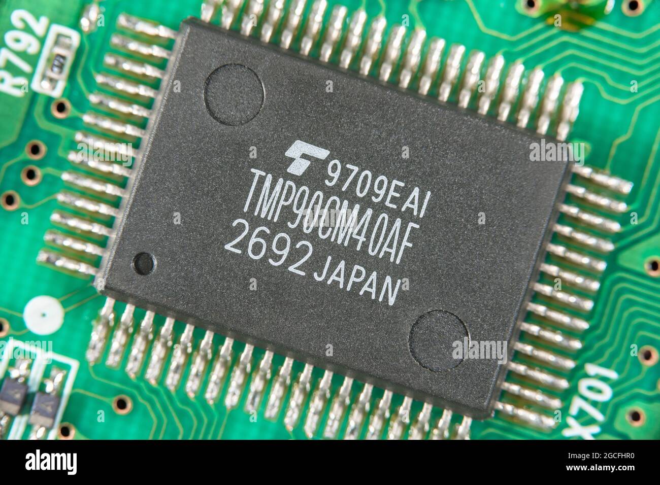 Makroaufnahme eines vermutlich von Toshiba produzierten CMOS 8-Bit-Mikrocontrollers aus Japan. Für den Mangel an Mikrochips, kleine elektronische Teile Stockfoto