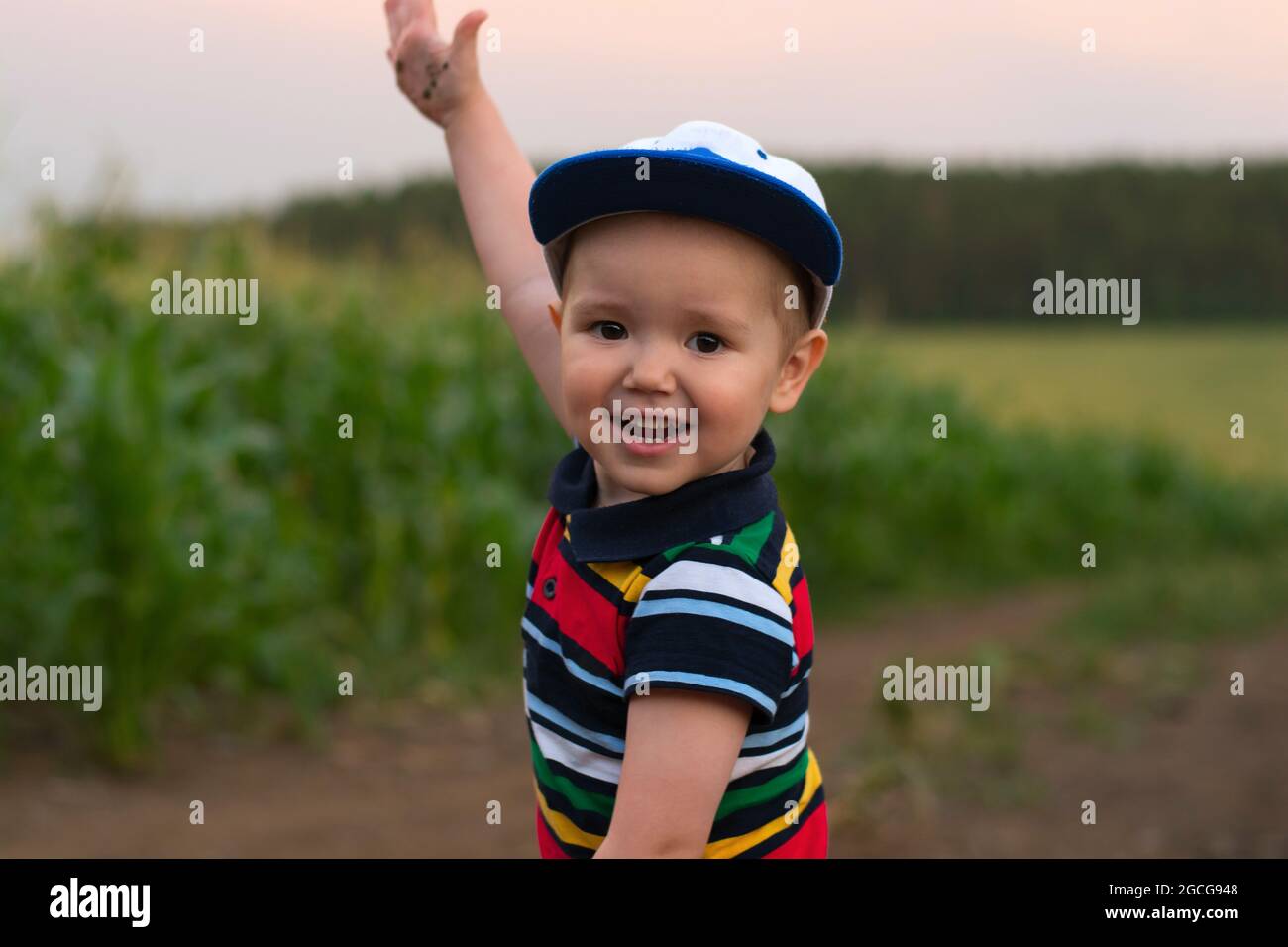 Ein kleiner Junge macht Gesichter und spielt in einem Kornfeld Stockfoto