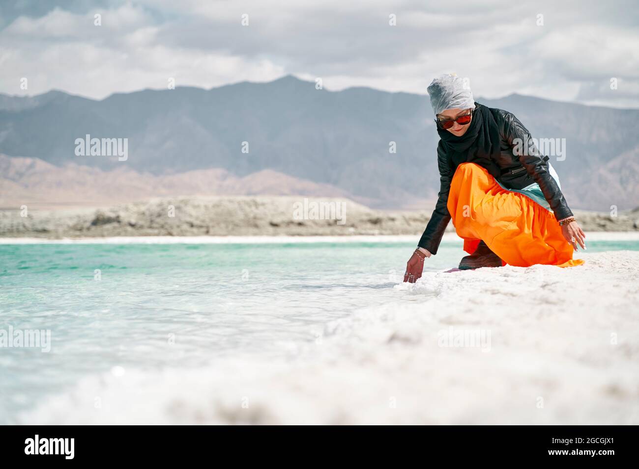 asiatische Frau weibliche Touristen berühren das Wasser eines Salzsees Stockfoto