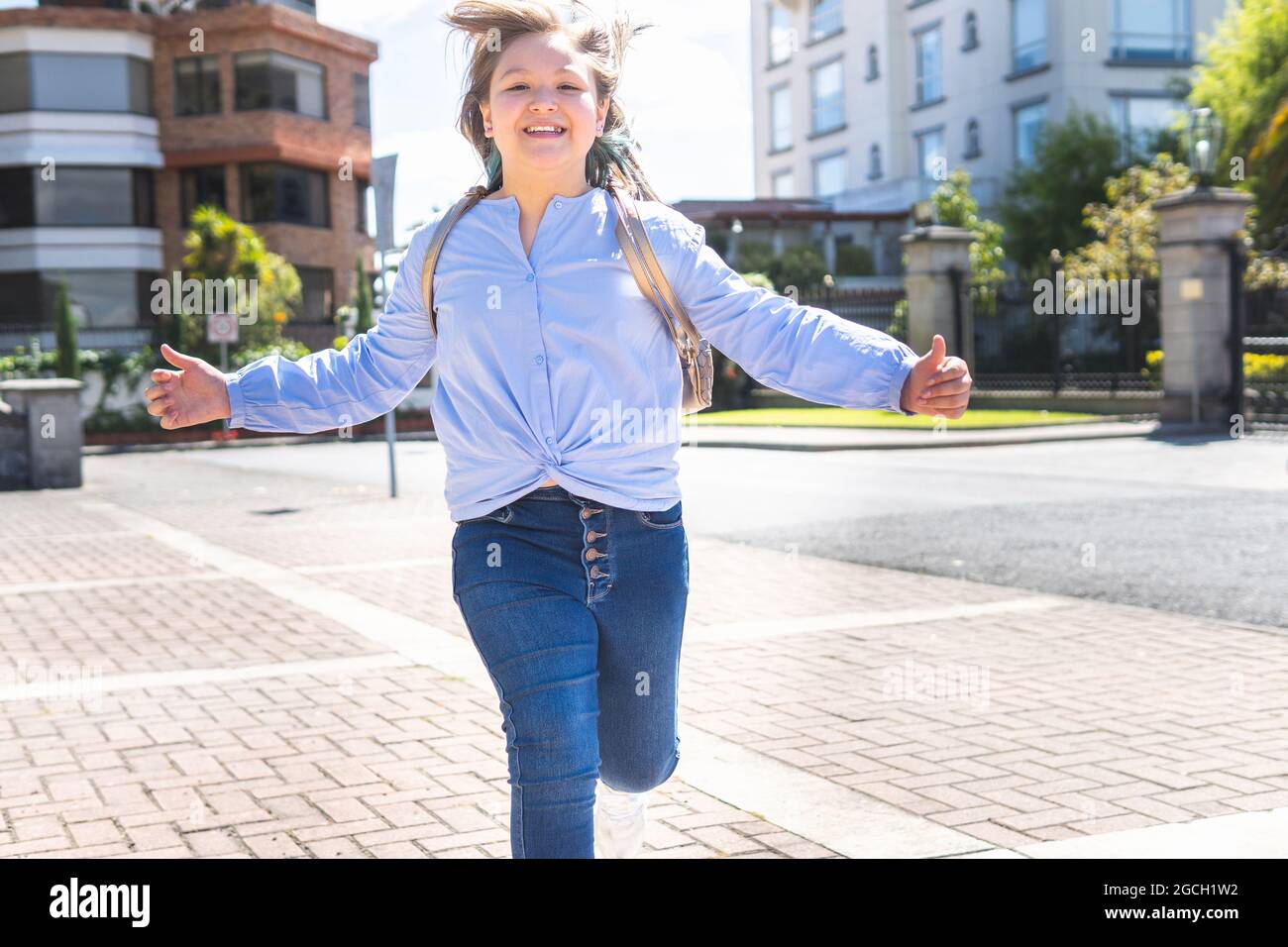 Mädchen läuft glücklich am Eingang zum Unterricht. Zurück zur Schule Stockfoto