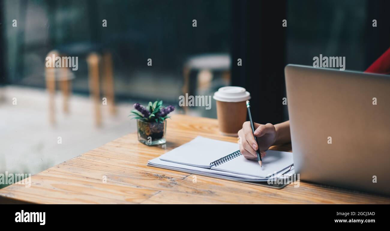 Nahaufnahme der Geschäftsfrau oder Buchhalterin Hand halten Stift arbeiten auf Rechner und Laptop-Computer, um Geschäftsdaten zu berechnen während notieren bei Stockfoto