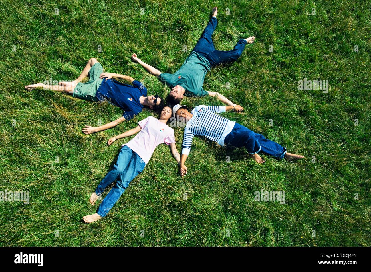 Gruppe von Freunden, die im Kreis auf Gras liegen Stockfoto