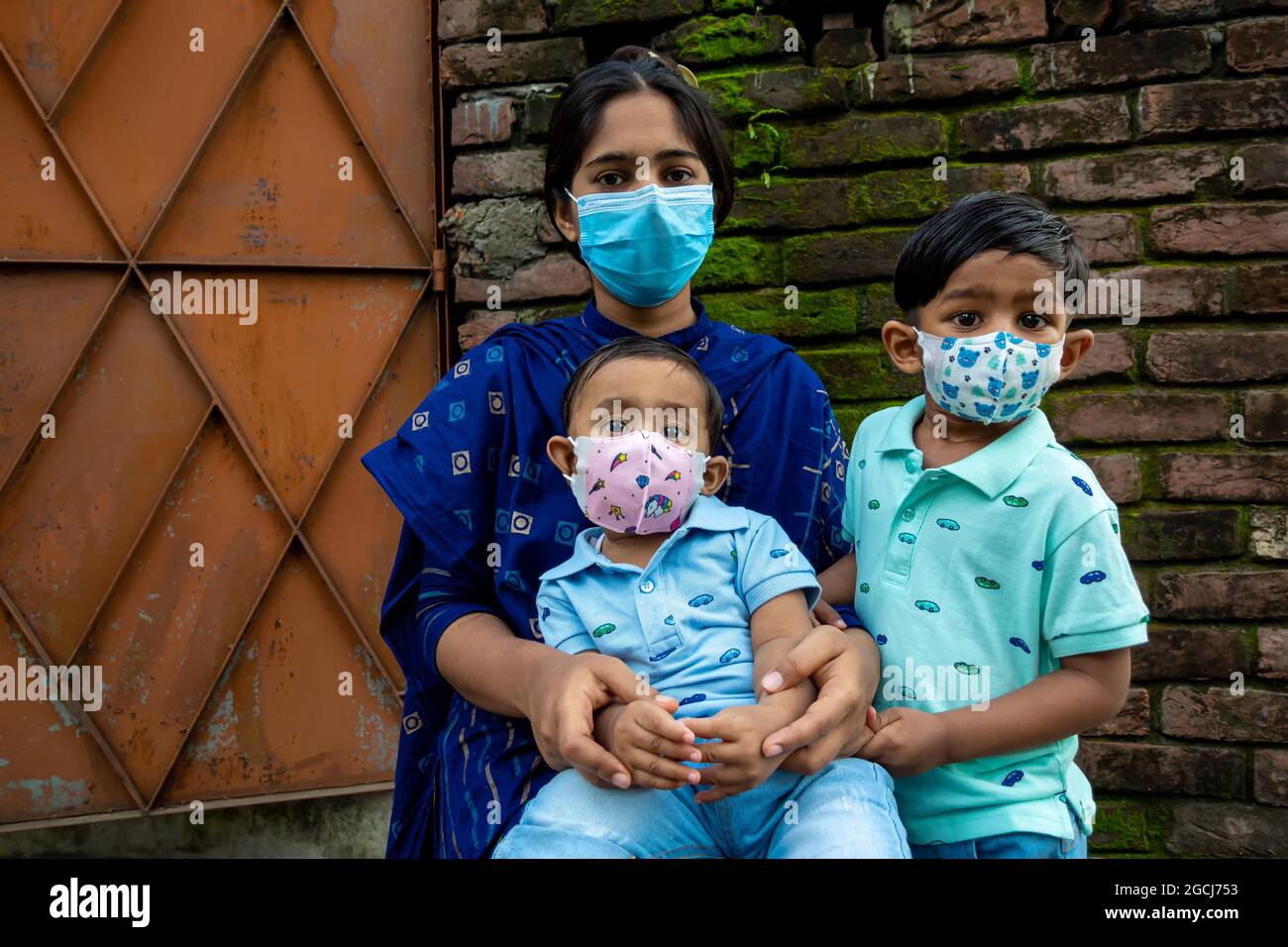 Eine asiatische Mutter und ihre beiden Kinder sehen die Kamera mit Sicherheitsmasken an. Covid-19 Epidemie, Sperrung und Quarantänezeit-Sicherheitskonzept. Edu Stockfoto