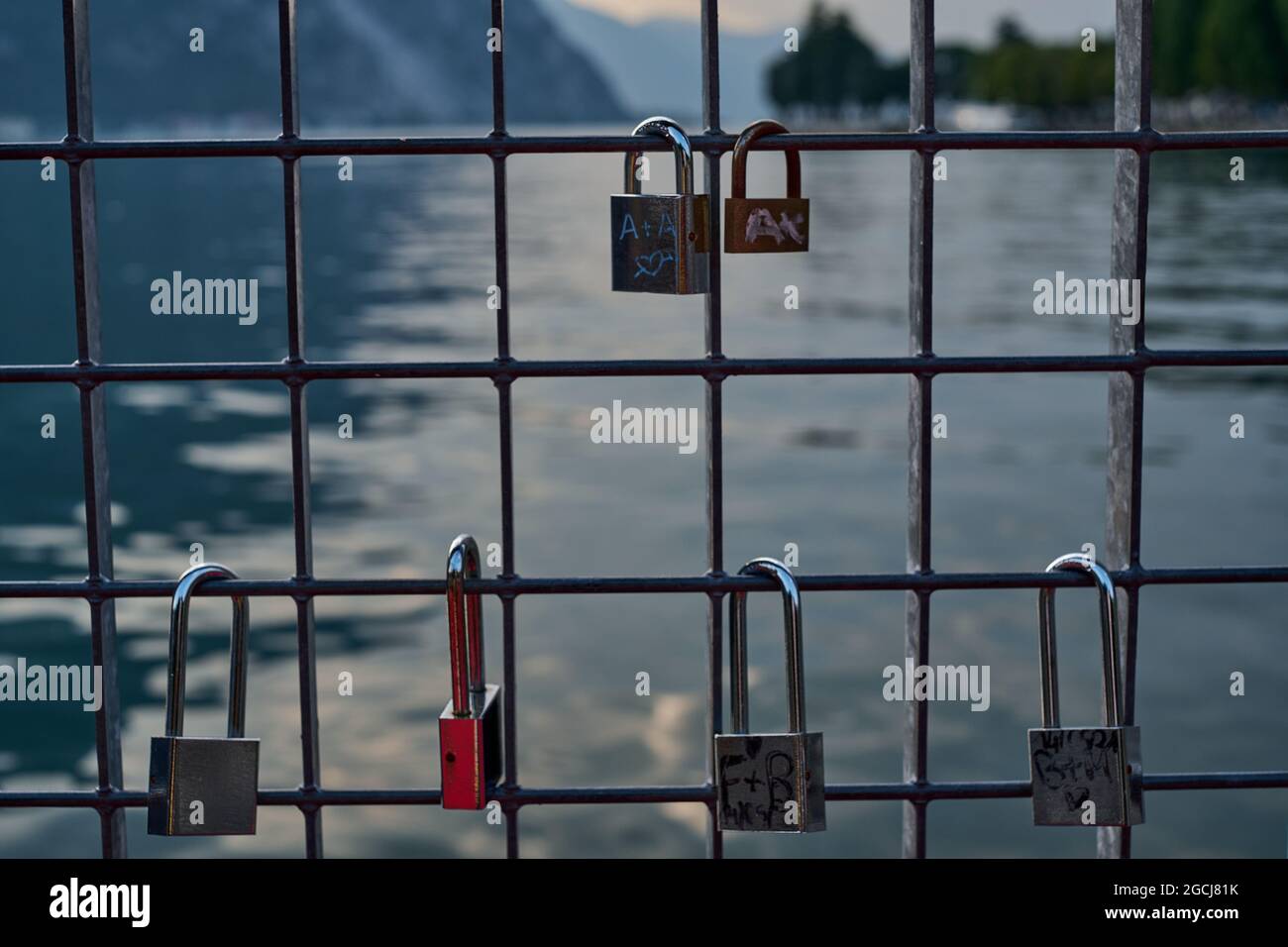 Verlassene Vorhängeschlösser Liebhaber am Zaun Como See im Hintergrund angebracht Stockfoto