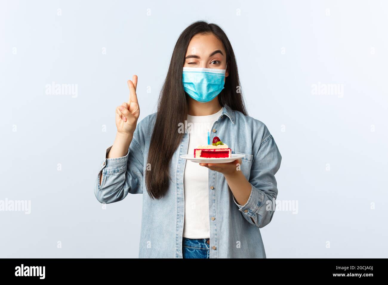 Sozialer distanzierender Lebensstil, covid-19 Pandemie, Feier der Feiertage während Coronavirus Konzept. Hoffnungsvoll niedlich asiatische Mädchen in medizinische Maske, halten Stockfoto