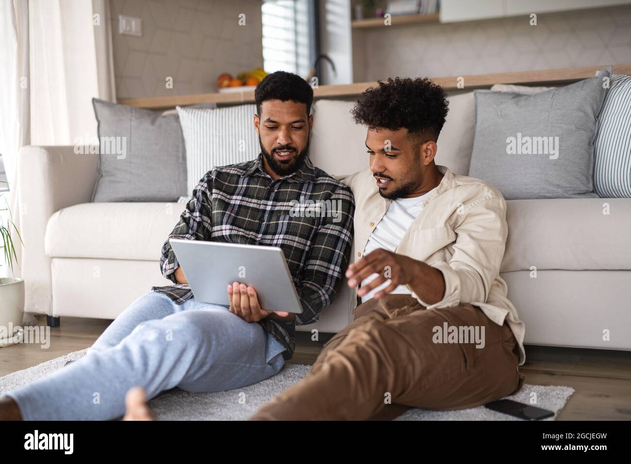 Junge Studenten Brüder in Küche drinnen zu Hause, mit Tablet. Stockfoto